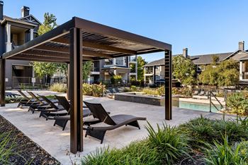 A patio with a pool and sun loungers. at Preserve at Rolling Oaks, Austin, TX, 78728